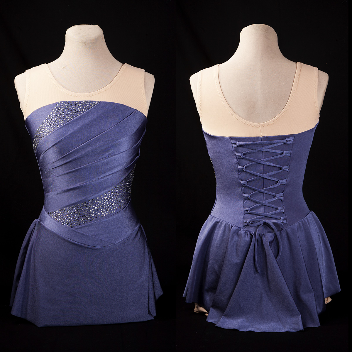 A steel blue custom figure skating dress with ruching and crystal accents on the front, and a lace up back.